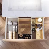 Badezimmerinspiration mit hellen Eichenmöbeln mit Lamellen, elegantem Doppelwaschbecken, schönem Spiegelschrank mit Licht, Fischgrätboden und weißer Marmorwand für ein klassisches, helles Aussehen.