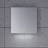 Stilvolle und minimalistische Badezimmereinspiration mit Mikro-Waschtisch und kleinem Waschtischschrank, quadratischem Spiegel mit abgerundeten Ecken und Lampe sowie elegantem Spiegelschrank.