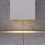 Kleines, stilvolles Badezimmer mit dunkelblauen Wänden, weichen gelben Badezimmermöbeln mit Rillen und elegantem rundem Spiegel mit Lampe.