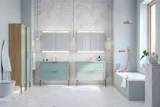 Große Badezimmerinspiration mit hellblauen Möbeln, eleganten Spiegelschränken und großen Marmorfliesen für einen klassischen, modernen Look