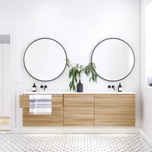 Nordisches Badezimmer aus Holz mit schönen runden Spiegeln mit schwarzen Kanten und viel Stauraum in den Badezimmermöbeln