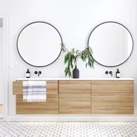 Nordisches Badezimmer aus Holz mit schönen runden Spiegeln mit schwarzen Kanten und viel Stauraum in den Badezimmermöbeln