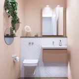 Kleine Badezimmerinspiration mit Waschbeckenunterschrank in Sonderfarbe mit integriertem Griff, Spiegelschrank mit Lampen, Dekorationsspiegel mit getöntem Glasregal, weiße Fischgrätfliesen für ein stilvolles und klassisches Aussehen.