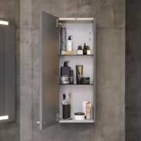 Badezimmer mit schrägen Wänden, grauem Waschtisch und Oberschrank, maßgefertigte Arbeitsplatten, modernes quadratisches Aufsatzwaschbecken, quadratischer Spiegel mit Beleuchtung, rohe Betonwände und -böden verleihen einen urbanen Ausdruck
