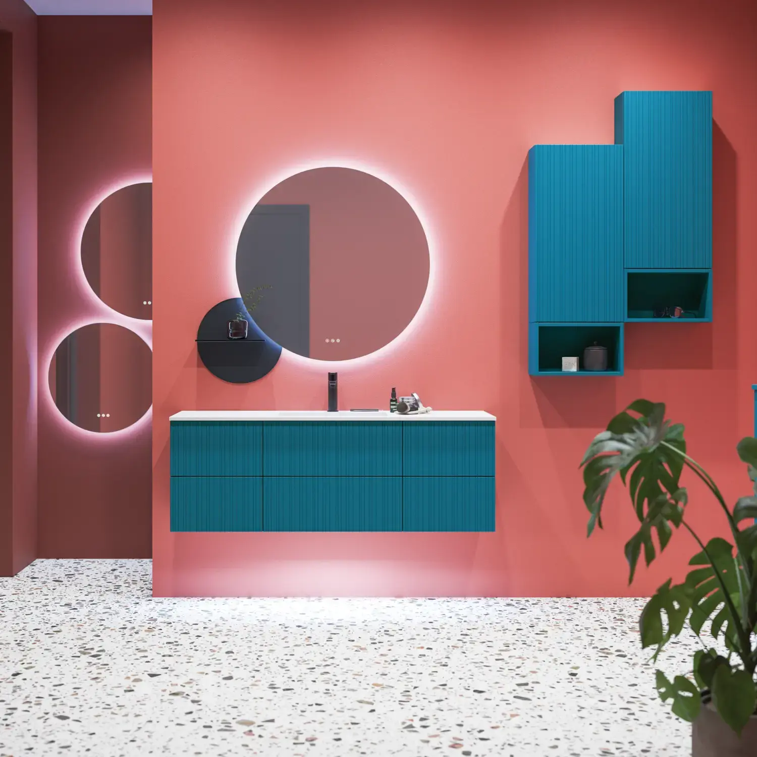 Große Badezimmerinspiration mit blauen Möbeln in Sonderfarbe mit Rillen, dünnem elegantem Waschbecken und schönen runden Spiegeln, roten Wänden und Terrazzoboden schaffen einen starken Kontrast zu den Möbeln und verleihen ein stilvolles, urbanes Aussehen.