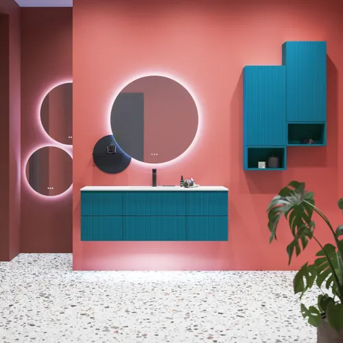 Große Badezimmerinspiration mit blauen Möbeln in Sonderfarbe mit Rillen, dünnem elegantem Waschbecken und schönen runden Spiegeln, roten Wänden und Terrazzoboden schaffen einen starken Kontrast zu den Möbeln und verleihen ein stilvolles, urbanes Aussehen.