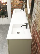Rohes und modernes Badezimmer im urbanen Stil. Schöne Waschtischunterschränke und runde Spiegel mit schwarzer Zierleiste