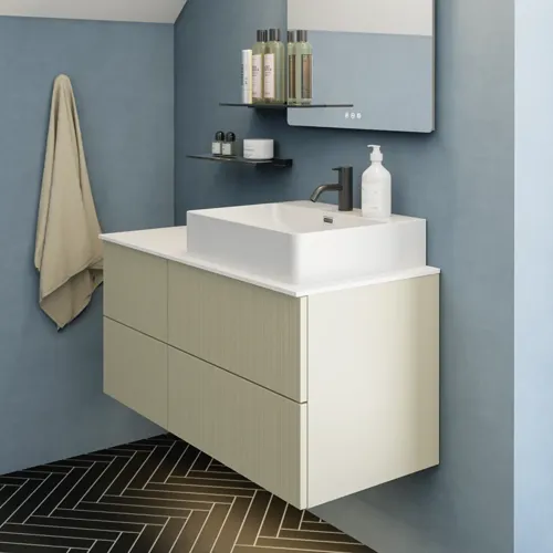 Badezimmer mit schräger Decke, beige Möbel mit Rillen, elegante Arbeitsplatte und quadratisches Waschbecken, schöner Spiegel mit Regalen, blaue Wände, große Fenster und schwarzer Fischgrätboden für ein helles, urbanes Aussehen.