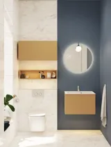 Kleines, stilvolles Badezimmer mit dunkelblauen Wänden, weichen gelben Badezimmermöbeln mit Rillen und elegantem rundem Spiegel mit Lampe