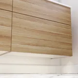 Nordisches Badezimmer aus Holz mit schönen runden Spiegeln mit schwarzen Kanten und viel Stauraum in den Badezimmermöbeln