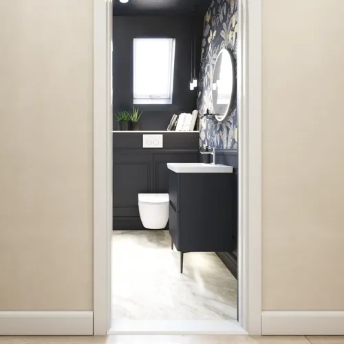 Badezimmer-Inspiration mit dunkelblauen Wandpaneelen, romantischer Blumen-Tapete, dunkelblauem Waschtischunterschrank mit weichen Formen und einem schönen runden Spiegel mit Beleuchtung, das ein Vintage-Flair verleiht