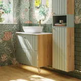 Badezimmerinspiration mit grünen Möbeln in Sonderfarbe mit Seiten aus naturbelassener Eiche, eleganten Rillen, stilvoller Arbeitsplatte mit ovalem Aufsatzwaschbecken, schönem ovalem Spiegel und Blumenmuster-Tapete für ein anmutiges, Retro-Aussehen.
