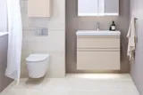 Kleine Badezimmer-Inspiration mit Waschtisch und Schrank über der Toilette in beige Spezialfarbe, eleganter Spiegelschrank mit integrierter Beleuchtung, die hellen Farben und der weiße Vorhang schaffen eine romantische und feminine Atmosphäre.