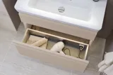 Kleine Badezimmer-Inspiration mit Waschtisch und Schrank über der Toilette in beige Spezialfarbe, eleganter Spiegelschrank mit integrierter Beleuchtung, die hellen Farben und der weiße Vorhang schaffen eine romantische und feminine Atmosphäre.