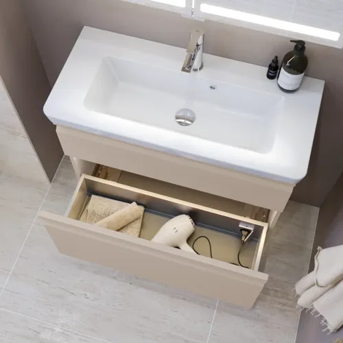 Kleine Badezimmer-Inspiration mit Waschtisch und Schrank über der Toilette in beige Spezialfarbe, eleganter Spiegelschrank mit integrierter Beleuchtung, die hellen Farben und der weiße Vorhang schaffen eine romantische und feminine Atmosphäre.