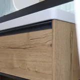 Badezimmerinspiration mit langen blauen Fliesen, Badezimmermöbeln aus naturbelassener Eiche mit schwarzen Details, die einen harmonischen und raffinierten Ausdruck schaffen