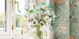 Badezimmerinspiration mit grünen Möbeln in Sonderfarbe mit Seiten aus naturbelassener Eiche, eleganten Rillen, stilvoller Arbeitsplatte mit ovalem Aufsatzwaschbecken, schönem ovalem Spiegel und Blumenmuster-Tapete für ein anmutiges, Retro-Aussehen.