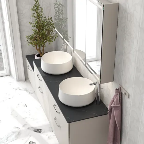 Romantische Badezimmer Inspiration mit Spiegelschrank, der praktische und anmutige Aufbewahrungslösungen bietet, doppelte Aufsatzwaschbecken auf einer Steinplatte.