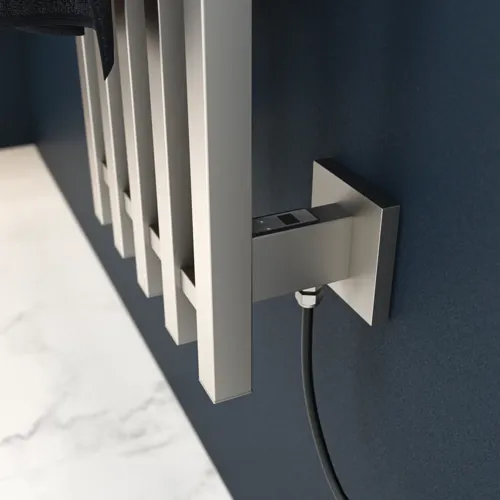 Elektrischer Handtuchwärmer an einer dunkelblauen Wand in einem stilvollen Badezimmer.