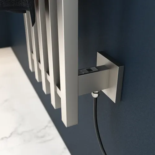 Elektrischer Handtuchwärmer an einer dunkelblauen Wand in einem stilvollen Badezimmer.