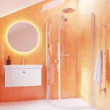 Badezimmer-Inspiration mit weißem Waschtisch mit rundem Spiegel, abgerundeten Duschtüren aus Klarglas und Profilen aus Satin, mit praktischem und stilvollem elektrischem Handtuchtrockner und Badregal.