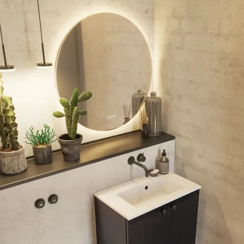 Badezimmerinspiration mit Waschtischunterschrank aus schwarzer Eiche sowie elegantem rundem Spiegel und Waschbecken, stilvollen Accessoires sowie Kaktuspflanzen und Wänden aus rohen Materialien verleihen einen rauen, industriellen und urbanen Look.