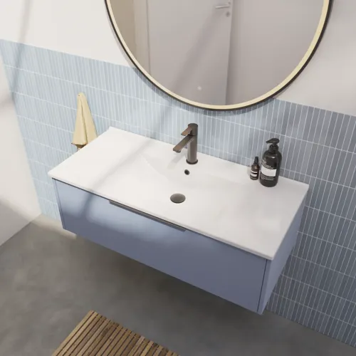 Badezimmerinspiration mit länglichen hellblauen Fliesen und Betonboden, elegantem hellblauem Waschtischunterschrank mit schmalen Streifen, stilvollem und dünnem Waschbecken sowie minimalistischem rundem Spiegel mit schwarzem Rand und Licht.