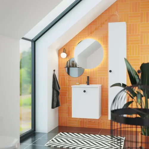 Badezimmer mit schräger Decke, inspiriert durch einen kleinen weißen Waschtisch und einen Hochschrank mit runden schwarzen Griffen, sowie einem schönen runden Spiegel, orangefarbene Fliesen geben einen frischen und modernen Look.