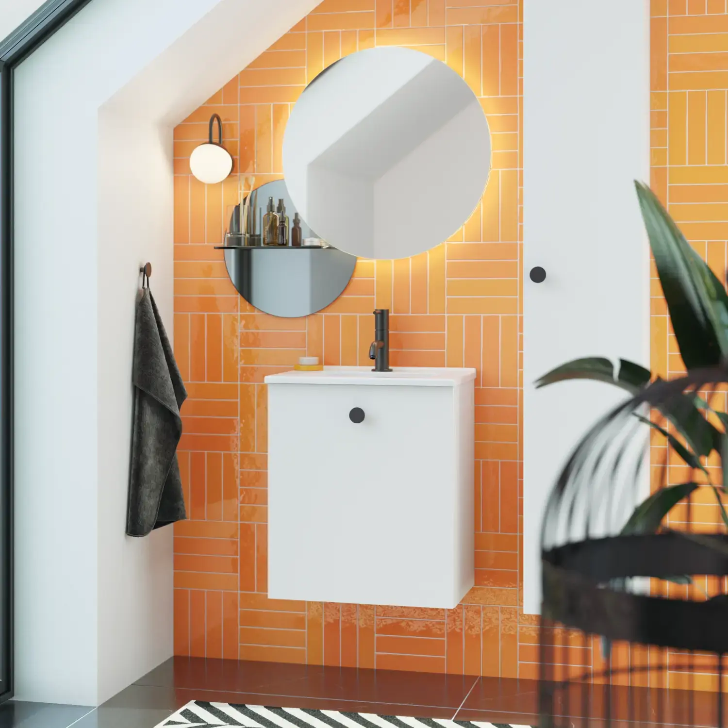 Badezimmer mit schräger Decke, inspiriert durch einen kleinen weißen Waschtisch und einen Hochschrank mit runden schwarzen Griffen, sowie einem schönen runden Spiegel, orangefarbene Fliesen geben einen frischen und modernen Look.