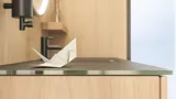 Stilvolles Badezimmer im skandinavischen und Japandi-Stil mit hellen Holzwänden, rundem Spiegel und minimalistischen Badezimmermöbeln.