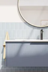 Badezimmerinspiration mit länglichen hellblauen Fliesen und Betonboden, elegantem hellblauem Waschtischunterschrank mit schmalen Streifen, stilvollem und dünnem Waschbecken sowie minimalistischem rundem Spiegel mit schwarzem Rand und Licht.