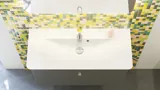 Inspiration für ein Badezimmer mit Badezimmermöbeln in mattem Grau, einem eleganten Waschbecken, einem schönen quadratischen Spiegel, einem grauen Fußboden und kleinen Fliesen in verschiedenen Gelb- und Grüntönen für einen hellen und verspielten Look