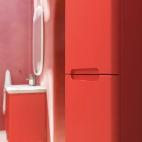 Badezimmer-Inspiration mit roten Wänden, sanft geformtem roten Waschtischunterschrank und Hochschrank, elegantem weißen Waschbecken und schönem ovalem Spiegel mit Beleuchtung, die zusammen mit der natürlichen Umgebung ein Vintage-Flair schaffen